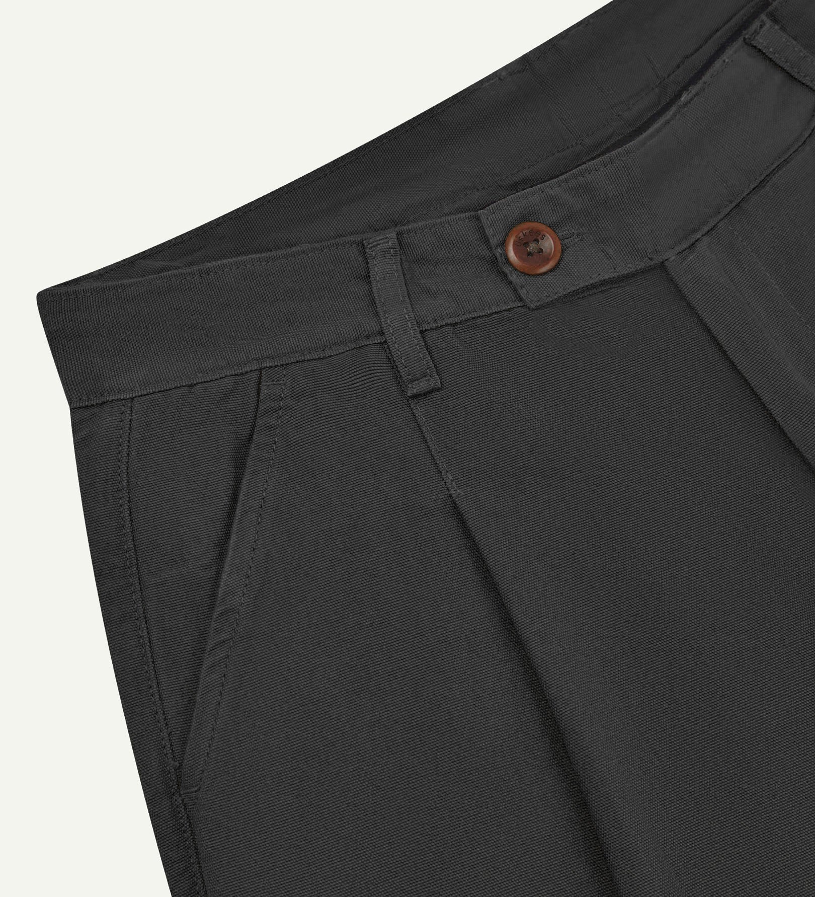 Front close-up shot of 5018 Uskees men's organic mid-weight cotton boat trousers in charcoal grey showing corozo button fastening at waistband, belt loops and front pocket.
