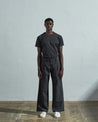 Full-length front view of model wearing Uskees #5018, charcoal-grey mid-weight cotton boat pants paired with faded black t-shirt.