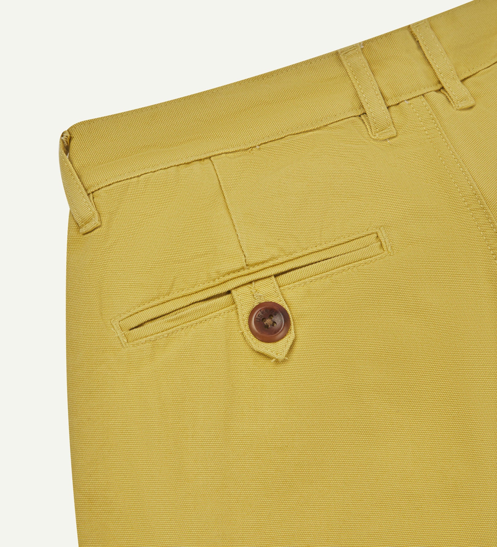 Back close-up view of 5018 Uskees men's organic mid-weight cotton boat trousers in acid acid yellow (citronella) showing belt loops and buttoned back pocket.