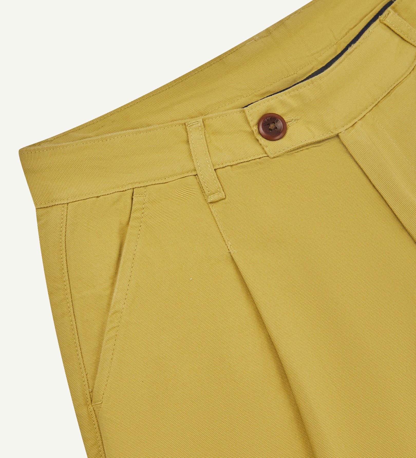 Front close-up shot of 5018 Uskees men's organic mid-weight cotton boat trousers in acid yellow (citronella) showing corozo button fastening at waistband, belt loops and front pocket.