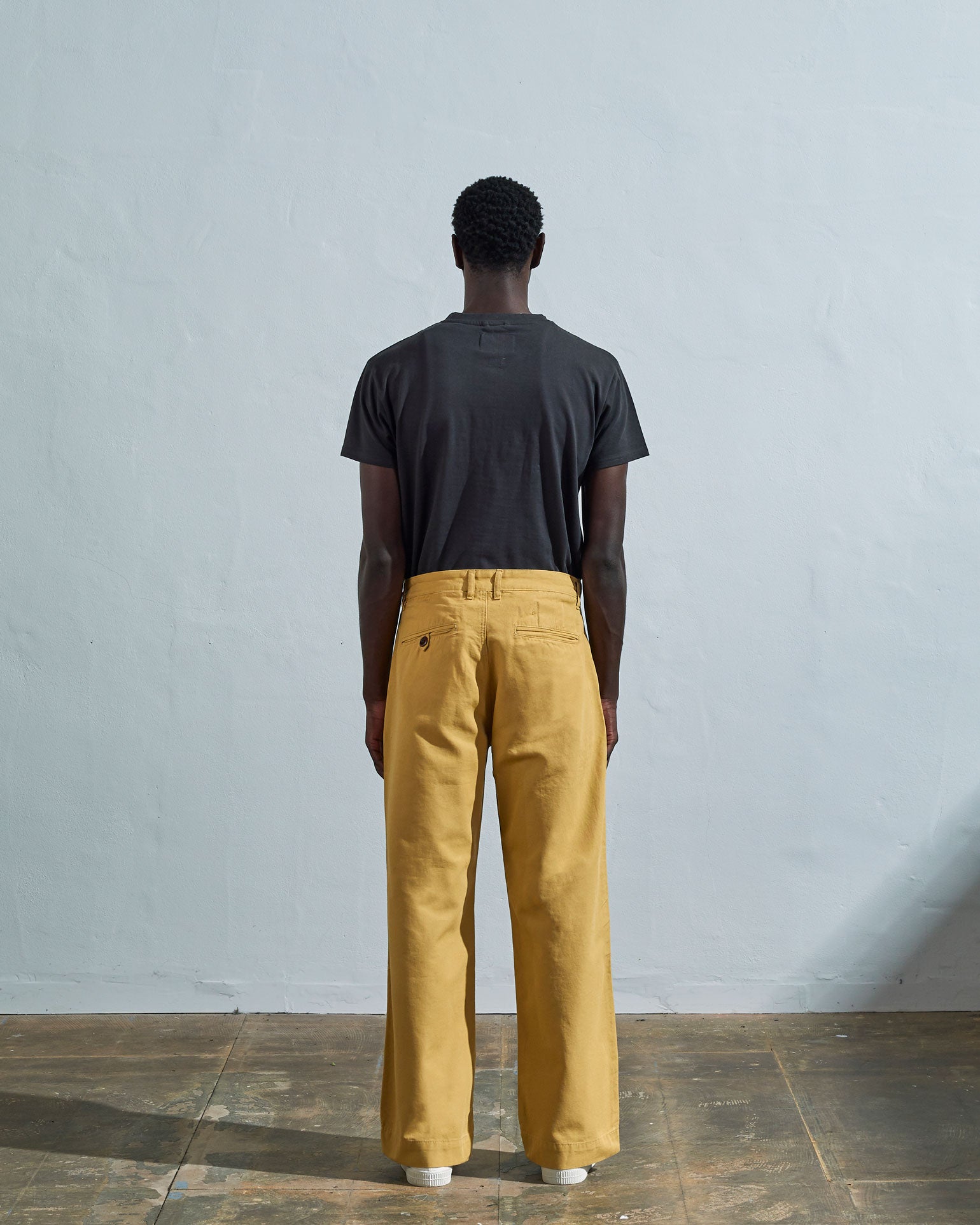 Full-length back view of model wearing #5018, citronella yellow mid-weight cotton boat pants. Showing rear pockets, belt loops and vintage inspired silhouette.