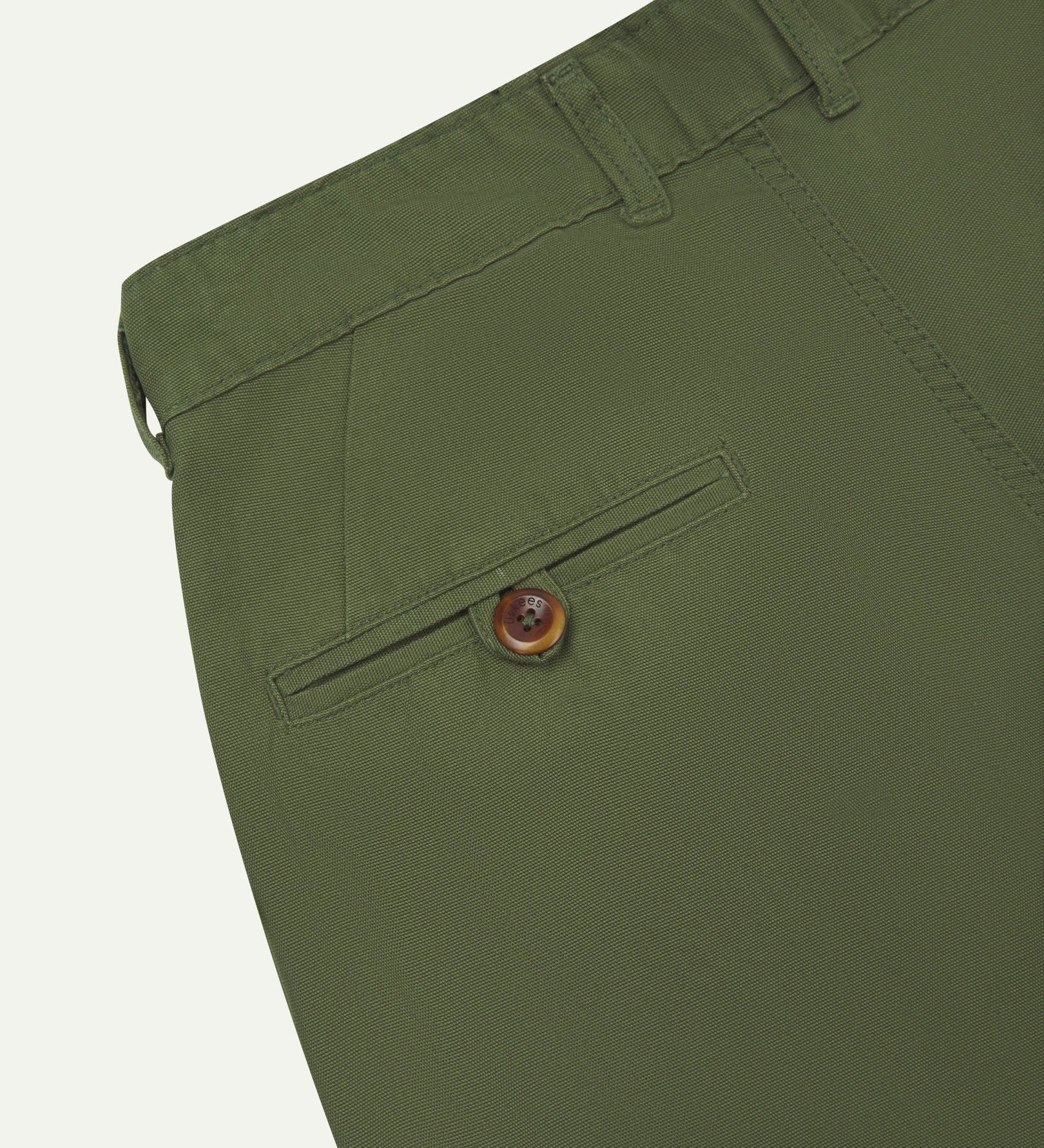 Back close-up view of 5018 Uskees men's organic mid-weight cotton boat trousers in coriander-green showing belt loops and buttoned back pocket.