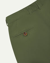 Back close-up view of 5018 Uskees men's organic mid-weight cotton boat trousers in coriander-green showing belt loops and buttoned back pocket.