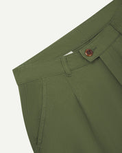 Front close-up shot of 5018 Uskees men's organic mid-weight cotton boat trousers in coriander-green showing corozo button fastening at waistband, belt loops and front pocket.