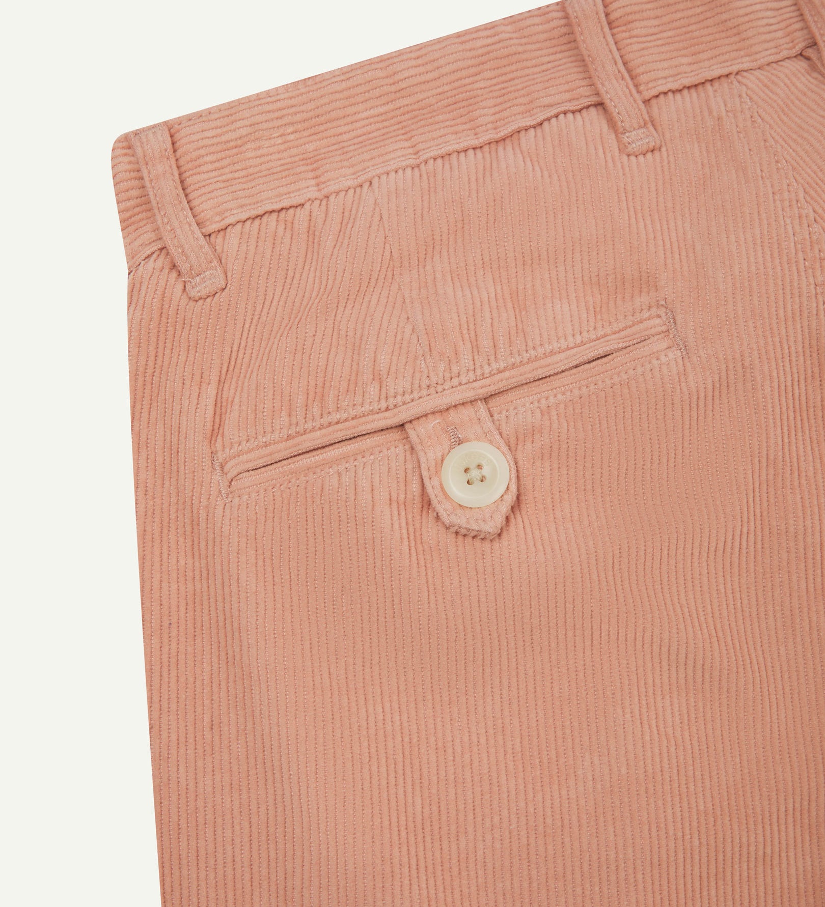 Close up back shot of Uskees 5018 cord boat pants in dusty pink with focus on neat back pocket secured with Corozo button and belt loops.
