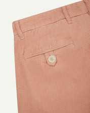 Close up back shot of Uskees 5018 cord boat pants in dusty pink with focus on neat back pocket secured with Corozo button and belt loops.