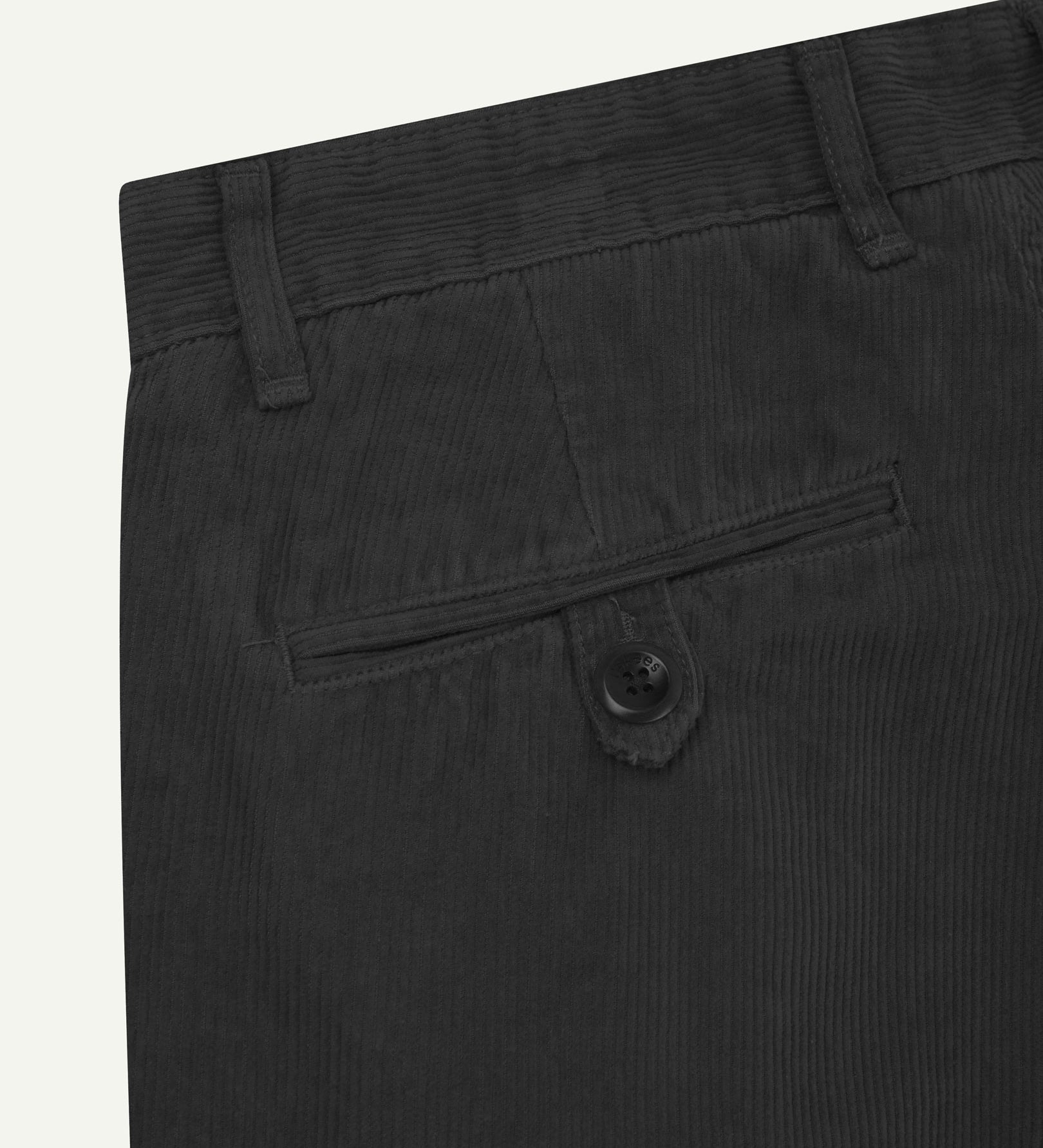 Close up back shot of Uskees 5018 cord boat pants in faded black with focus on neat back pocket secured with Corozo button and belt loops.