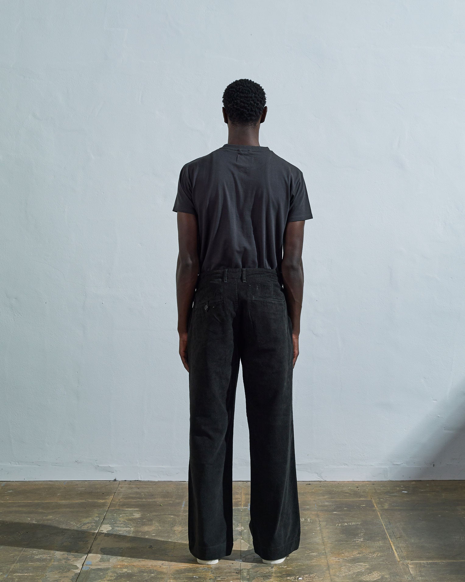Full-length back view of model wearing #5018, faded black corduroy boat pants. Showing rear pockets, belt loops and vintage inspired silhouette.