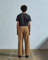 Full-length front view of model wearing Uskees #5018, khaki-brown mid-weight cotton boat pants paired with faded black t-shirt.