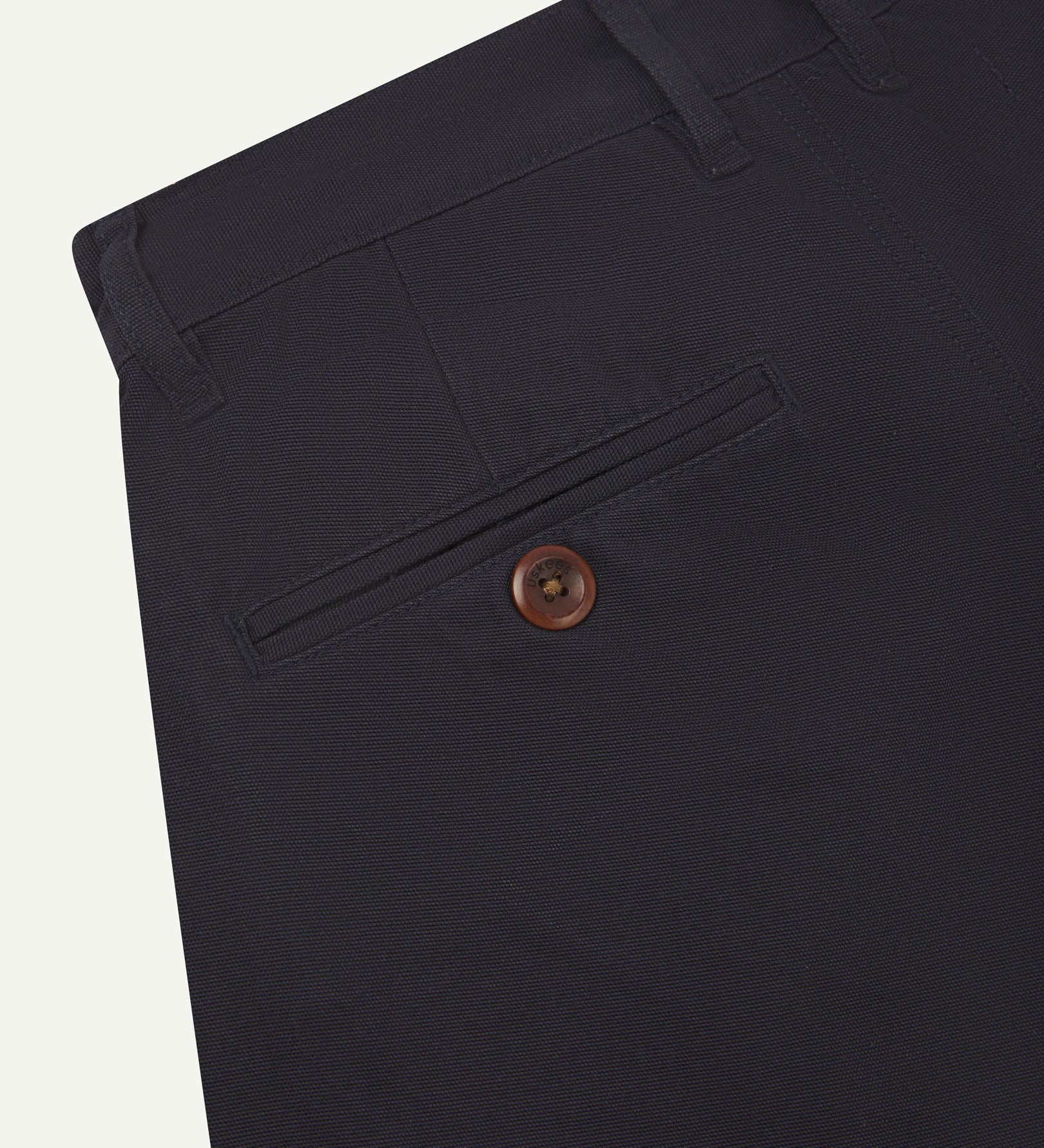 Back close-up view of 5018 Uskees men's organic mid-weight cotton boat trousers in acid midnight blue showing belt loops and buttoned back pocket.