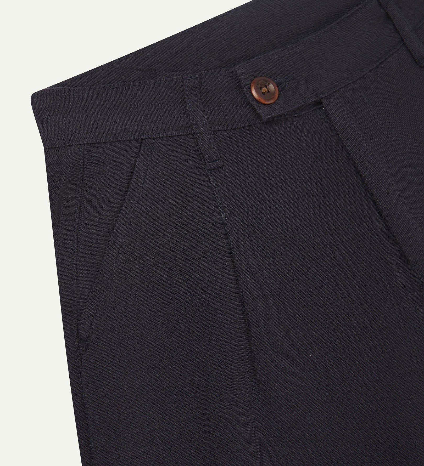 Front close-up shot of 5018 Uskees men's organic mid-weight cotton boat trousers in midnight blue showing corozo button fastening at waistband, belt loops and front pocket.