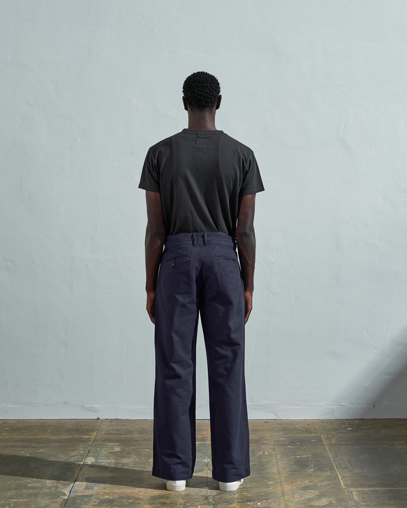 Full-length back view of model wearing #5018, midnight blue mid-weight cotton boat pants. Showing rear pockets, belt loops and vintage inspired silhouette.