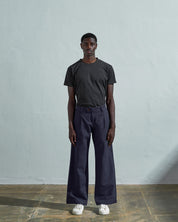 Full-length front view of model wearing Uskees #5018, midnight blue mid-weight cotton boat pants paired with faded black t-shirt.