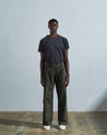 Full length back-view of model wearing vine-green corduroy #5018 trousers with view of rear pockets and belt loops and demonstrating vintage wide leg fitting.