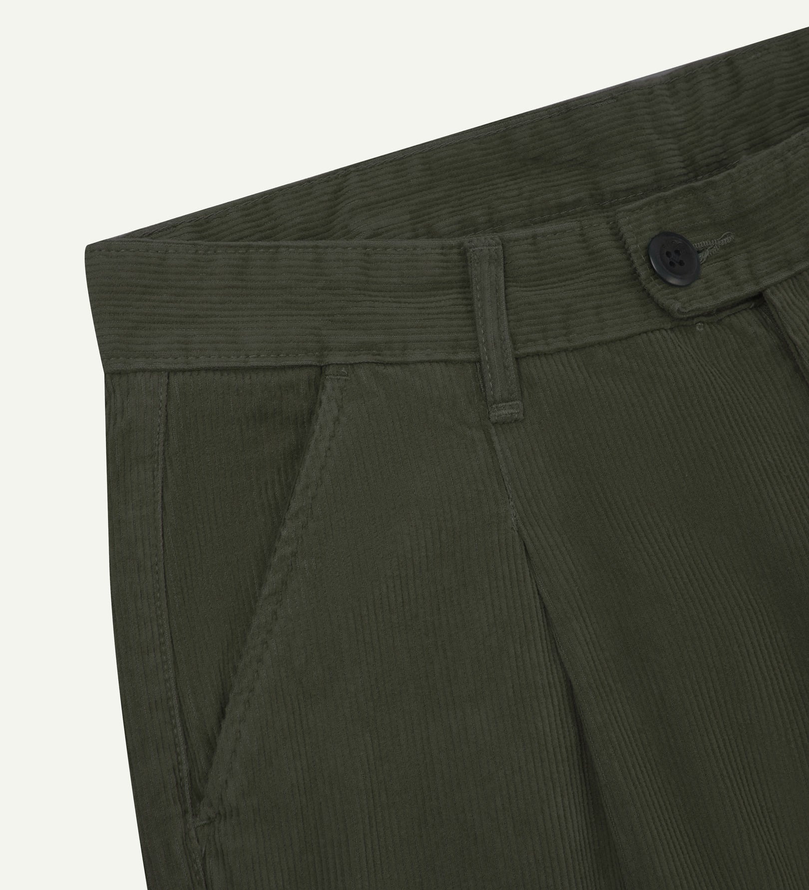 Close up of waist area of Uskees cord boat pants in vine green. Clear view of front pocket, belt loops and Corozo button fastening.