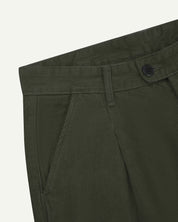 Close up of waist area of Uskees cord boat pants in vine green. Clear view of front pocket, belt loops and Corozo button fastening.