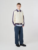 Full-length view of model wearing 5020 drill utility pants in blueberry. Indicating tapered fit on the leg, deep front pockets and reinforced knee patches. 