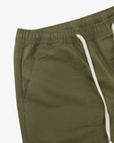 Close up front view of the front welt pocket, elasticated waist and tie of the ivy green ripstop pants from Uskees.