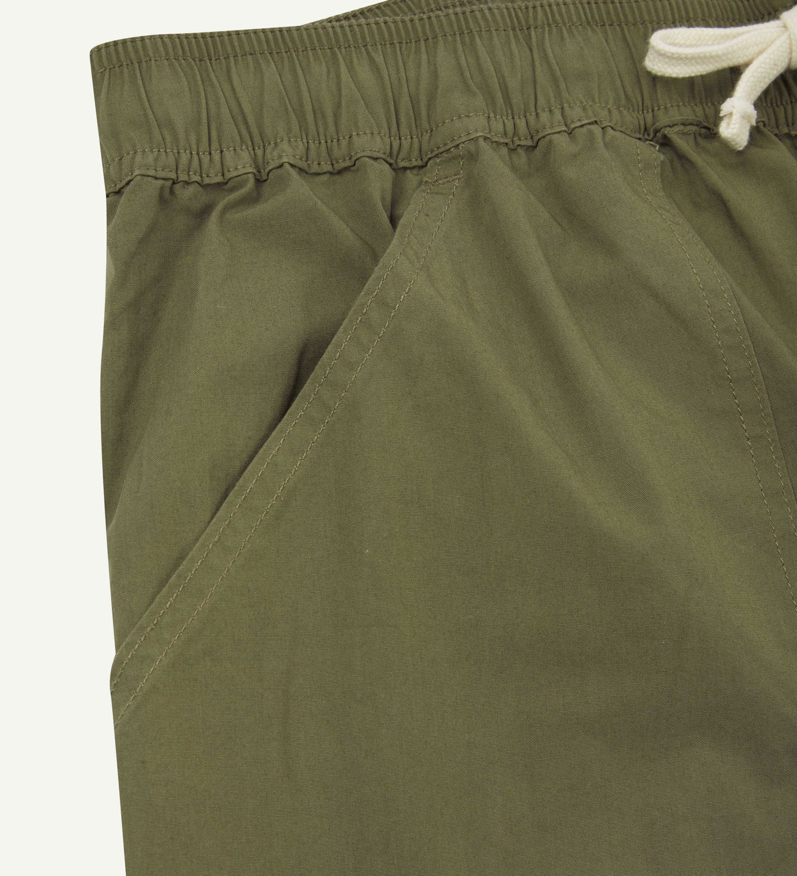 Front close-up shot of Uskees 5020 lightweight utility pants in olive-green showing waist and front pocket detail.