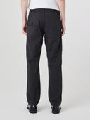 Close-up back view modelling 5021 Uskees men's organic twill black painter pants highlighting back patch pockets and gradual, narrowing leg.