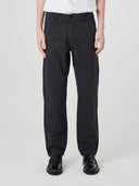 Close-up front view modelling 5021 Uskees men's organic twill black painter pants highlighting relaxed, flattering fit.