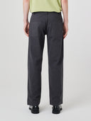 Close-up back view modelling 5021 Uskees men's organic twill charcoal grey painter pants highlighting back patch pockets and gradual, narrowing leg.