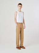 Full-length view modelling 5021 Uskees men's organic twill khaki painter pants paired with white Uskees vest.