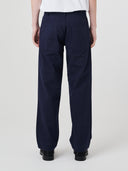 Close-up back view modelling 5021 Uskees men's organic twill midnight blue painter pants highlighting back patch pockets and gradual, narrowing leg.
