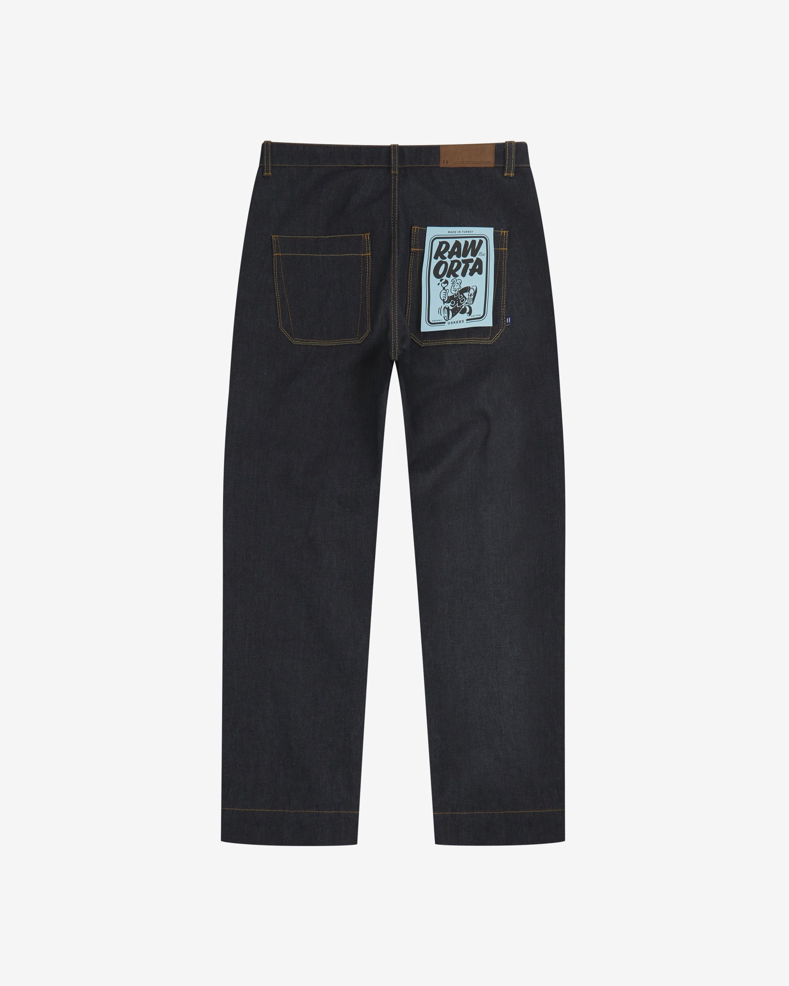 Full-length back view of Uskees 5021 raw orta denim workwear pants in dark indigo showing belt loops, back pockets with 'Raw Orta' cardboard pocket plaster.