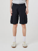Bottom-half front view of male model wearing black 5023 men's ripstop cargo shorts with clear view of deep cargo front patch pockets.
