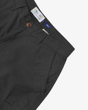 Close-up, angled front view of black 5023 men's ripstop cargo shorts. Clear view of a side pocket, corozo button, Uskees branding label and the weave of the ripstop fabric.