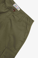 Close up front view of the front side pocket, branding label, corozo button and belt loops of the ivy green ripstop shorts from Uskees.