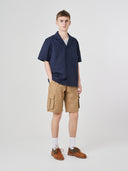 Full-length front view of male model wearing 5023 men's ripstop cargo shorts in khaki, paired with dark blue short-sleeve shirt.