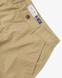 Close up front view of the front side pocket, branding label, corozo button and belt loops of the khaki ripstop shorts from Uskees.