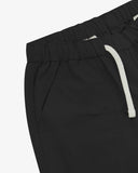 Close up front view of the front welt pocket, elasticated waist and tie of the black ripstop shorts from Uskees.