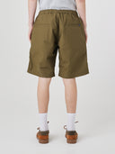 Bottom-half back view of male model wearing ivy green 5024 men's ripstop utility shorts with clear view of jetted back pockets and small Uskees tab label.