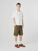 Full-length front view of male model wearing 5024 men's ripstop utility shorts in ivy green, paired with off-white short-sleeve shirt.