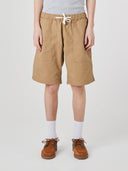 Bottom-half front view of male model wearing khaki 5024 men's ripstop utility shorts with clear view of deep utility front patch pockets.