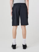 Back view of model wearing Uskees 5026 black Technique trekking shorts with dark t-shirt. View of 3 back pockets.