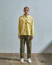 Full-length front view of model wearing #6001, banana over shirt paired with #5011 lightweight pants in olive.