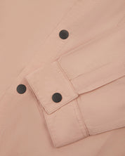View of the mid-section of the dusty pink 6001 lightweight overshirt from Uskees, with focus on the popper buttons and reinforced cuff, placket and sleeve.