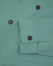 View of the mid-section of the blue-green eucalyptus 6001 lightweight overshirt from Uskees, with focus on the popper buttons and reinforced cuff, placket and sleeve.