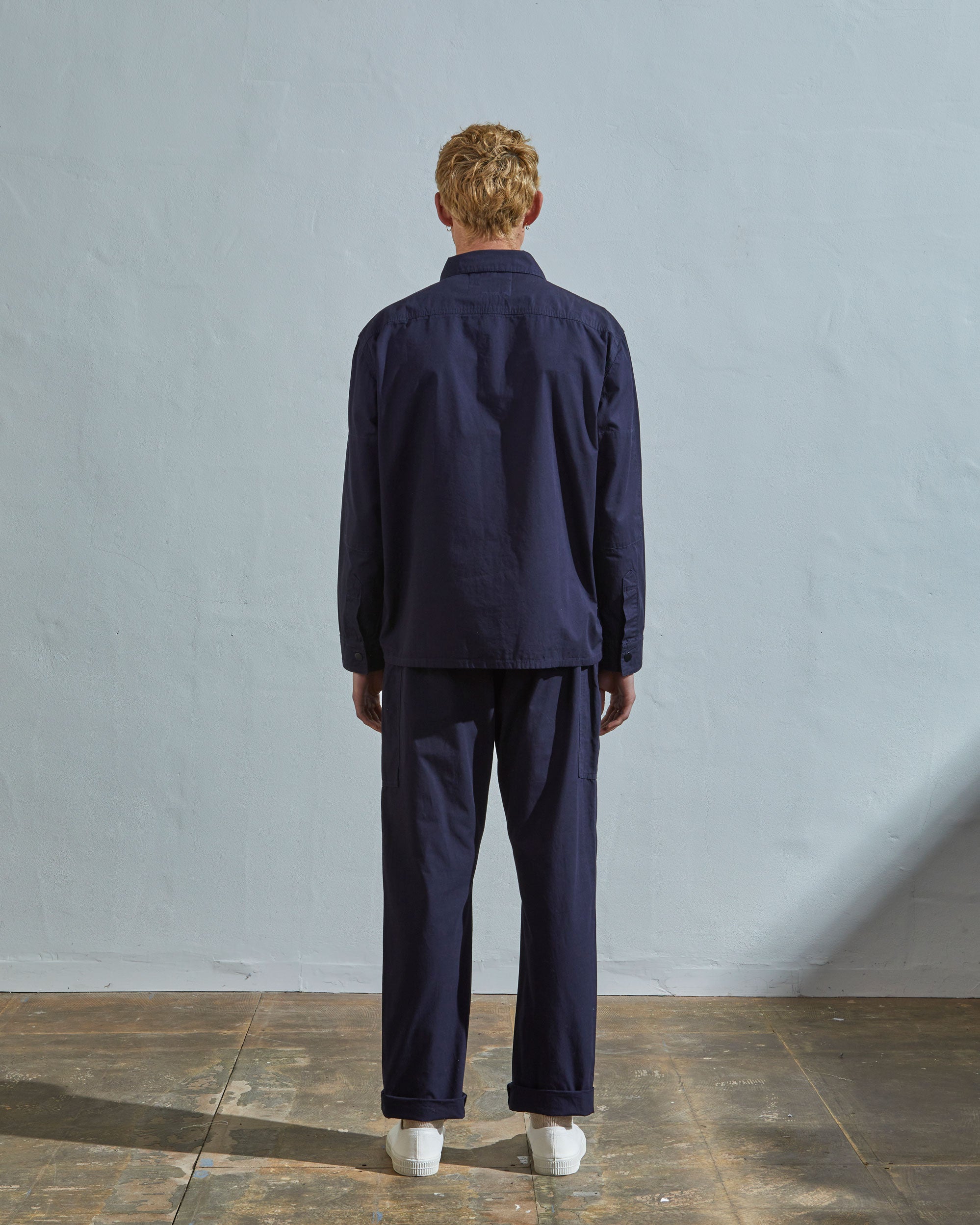 Full-length rear view of model wearing #6001, midnight blue over shirt showing reinforced elbows.