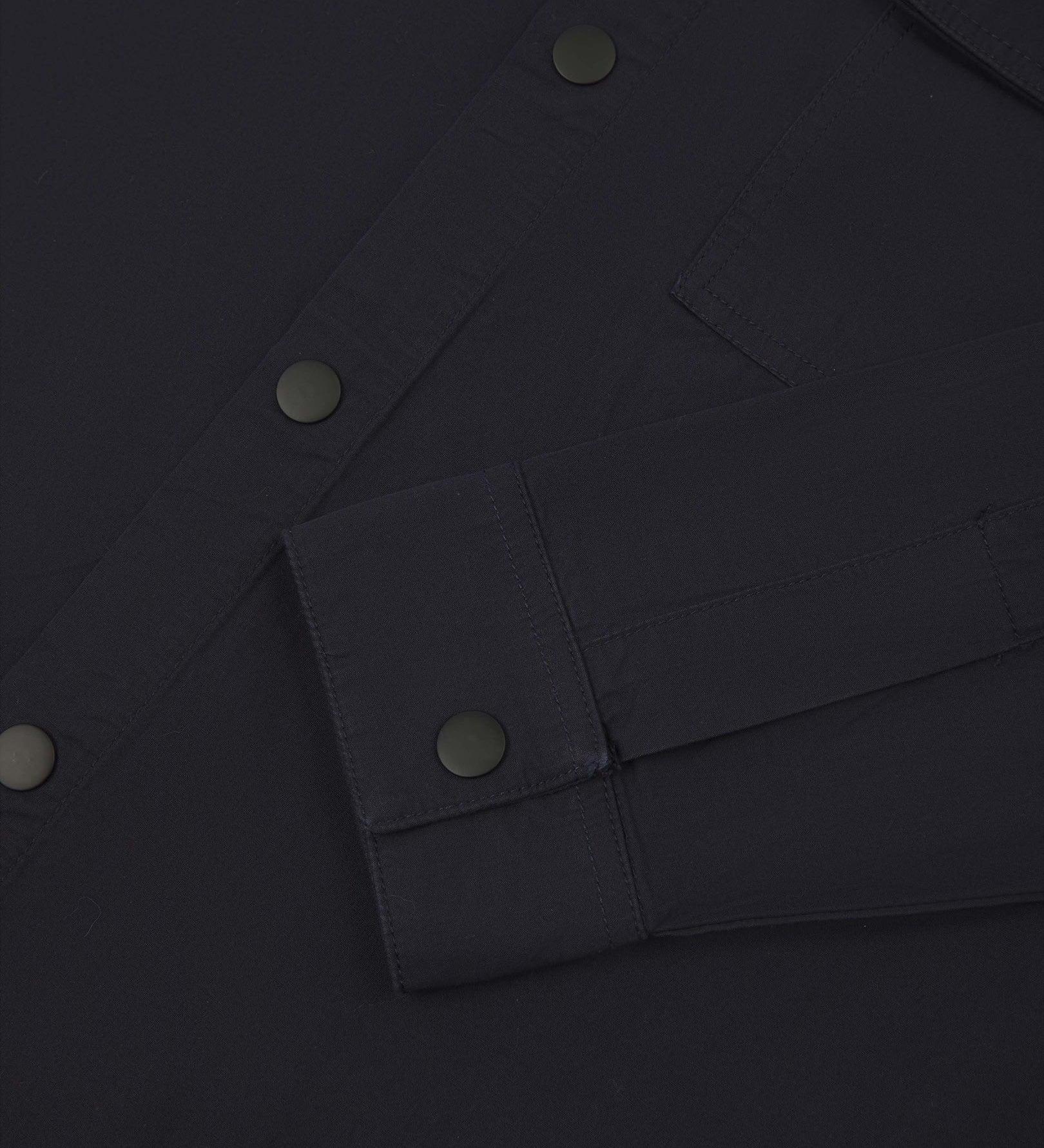 View of the mid-section of the midnight blue 6001 lightweight overshirt from Uskees, with focus on the popper buttons and reinforced cuff, placket and sleeve.