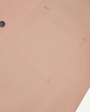 Angled mid-view of #6003 Uskees buttoned lightweight short sleeve shirt in dusty pink with focus on breast pocket.