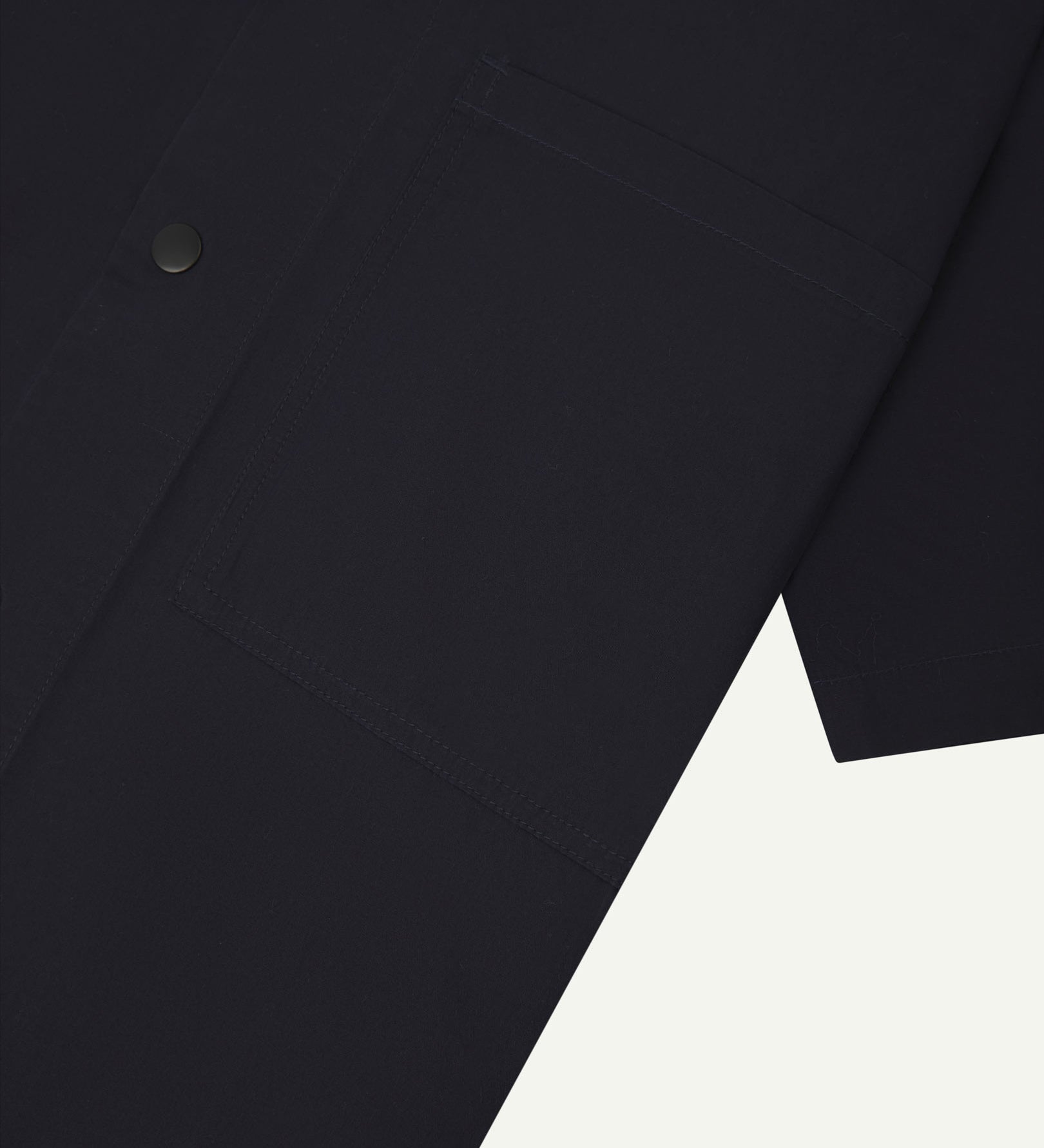 Angled mid-view of #6003 Uskees buttoned lightweight short sleeve shirt in midnight blue with focus on breast pocket.