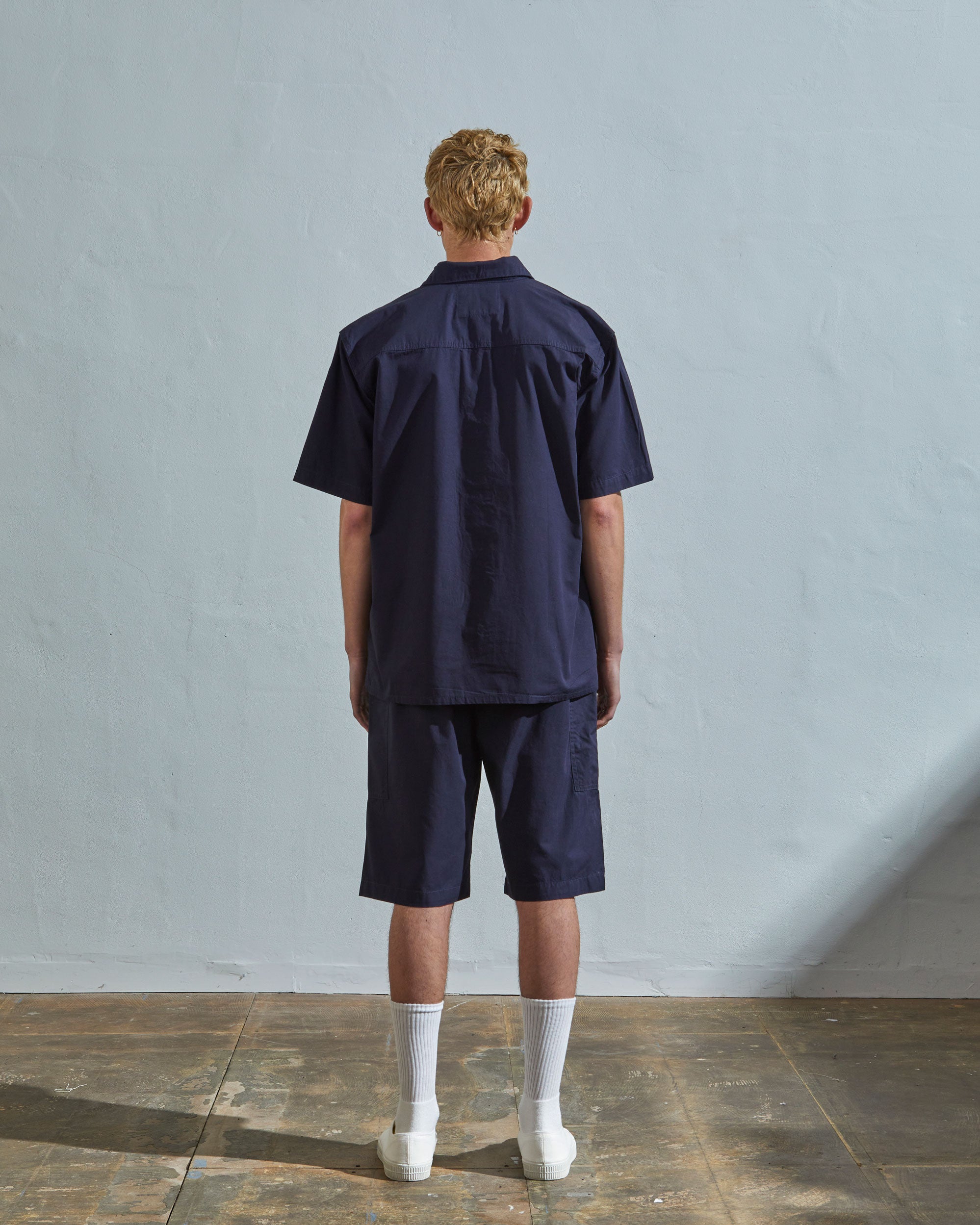 Full-length rear view of model wearing #6003 cotton shirt with matching lightweight midnight blue shorts.
