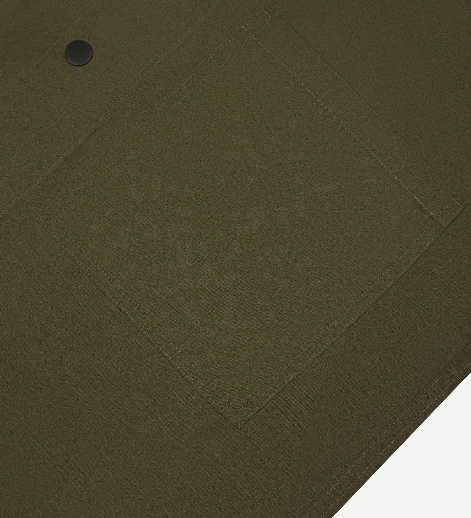 Angled mid-view of #6003 Uskees buttoned lightweight short sleeve shirt in olive-green with focus on breast pocket.