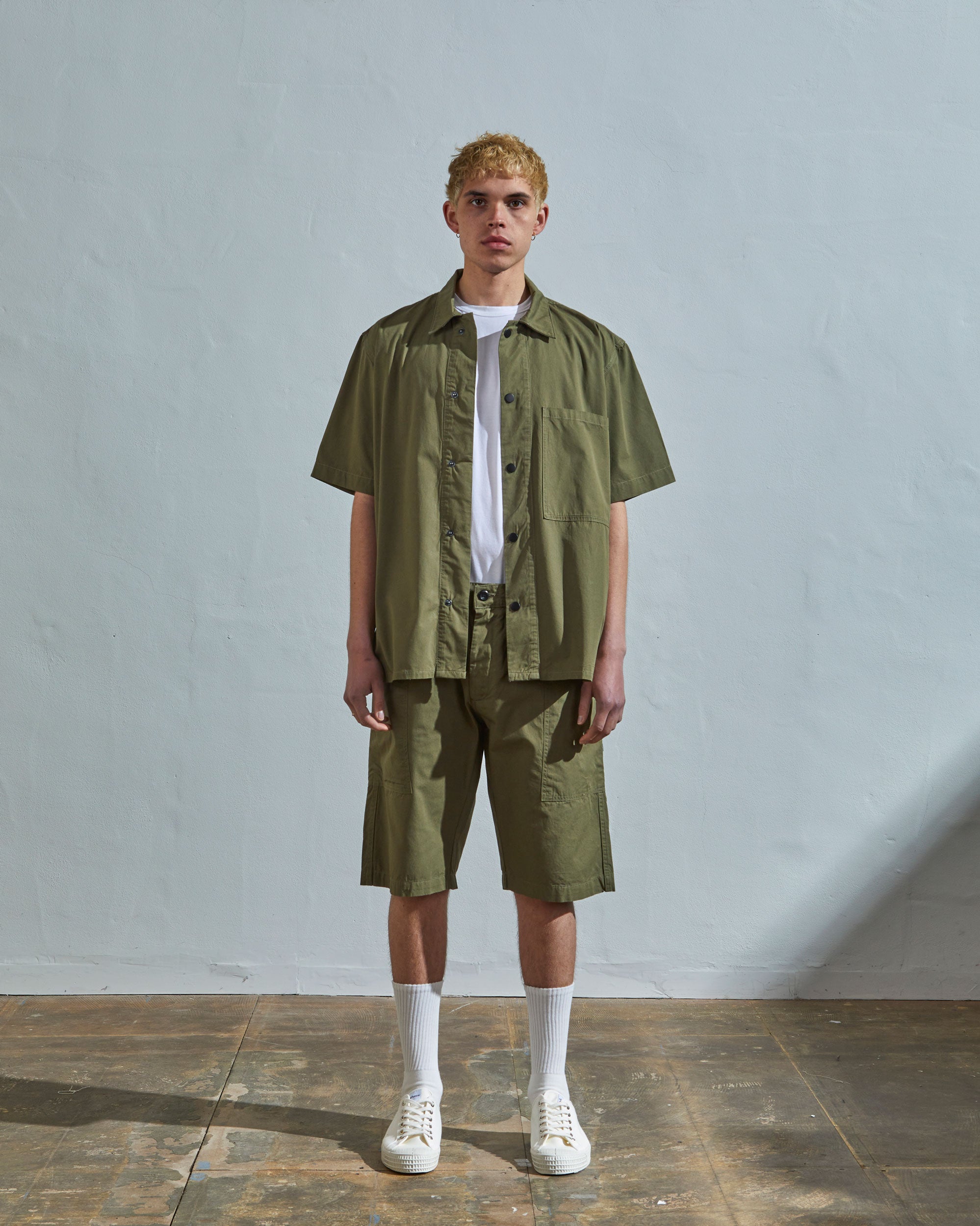 Full-length front view of model wearing #6003, olive lightweight short sleeve shirt paired with matching #5015 Uskees shorts.