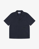 Front flat shot of Uskees dark blue Cuban short sleeve shirt for men. Clear view of corozo buttons, chest pocket and Uskees branding label.